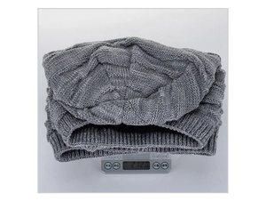 Detailansicht der grauen Strickmütze auf einer Digitalwaage mit Gewicht von 212 Gramm