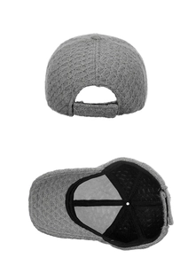 Detail view of grey knitted baseball cap with honeycomb texture and adjustable back strap