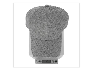Detailed view of dark grey knitted baseball cap weighing 122g on a scale