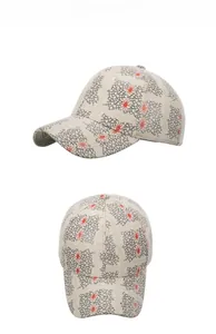 Close-up of beige baseball cap with black mesh pattern and orange star design details