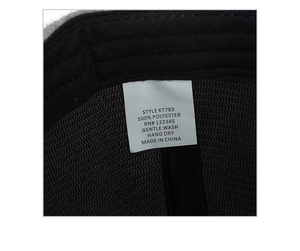 Detail view of the interior care label for a warm polyester baseball cap showing size and fabric