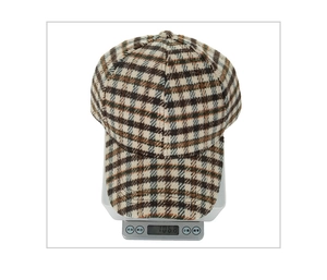 Weight measurement of the thick plaid baseball cap showing 106.8g on a digital scale