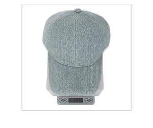 Detail shot showing a fuzzy winter baseball cap weighing 131.6g on a digital scale
