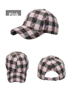 Detail view of pink plaid tweed baseball cap featuring textured fabric and silver metal buckle