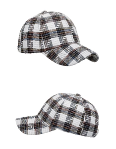 Close-up of black and white plaid tweed baseball cap with colorful accent threads