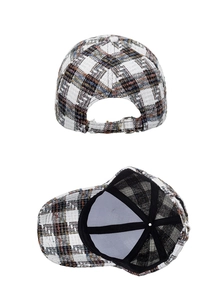 Detail of tweed plaid baseball cap showing metal adjustment buckle and inner lining