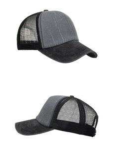 Detail view of washed grey cotton and black mesh trucker hat with curved brim stitching