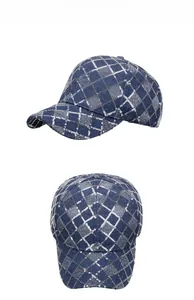 Détail d'une casquette en denim avec motif quadrillé à paillettes argentées et broderie