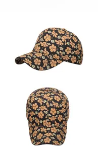 Detail view of floral baseball cap with orange hibiscus patterns and curved brim