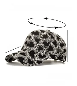 Close-up of black baseball cap featuring intricate white heart lace embroidery and texture