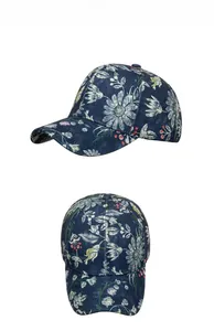 Detail of navy blue denim baseball cap with white daisy and red berry floral patterns