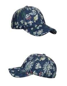 Detail view of floral print baseball cap with navy blue denim texture and white blossoms