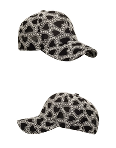 Close-up of heart-shaped lace embroidery on black and white baseball cap textures