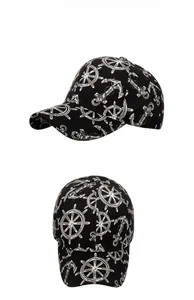 Detail showing a black cotton baseball cap with white nautical anchor and helm prints