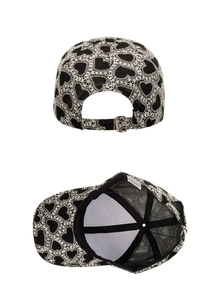 Detail view of heart embroidery pattern and metal buckle on black baseball cap