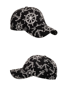 Detail view of black baseball cap with white nautical anchor and helm prints on side