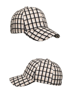 Detail of classic plaid baseball cap with black and beige checkered pattern and stitching