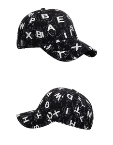 Detailed close-up showing the black cotton baseball cap with white letter prints