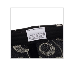 Detailed close-up of the 100% polyester wash care label on a black baseball cap
