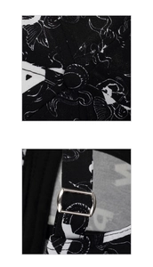 Close-up of adjustable metal buckle and embroidered pattern on black cotton baseball cap