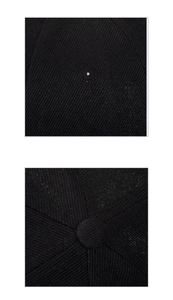 Detailed macro shot of black twill fabric texture and top button stitching on baseball cap