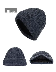 Macro view of navy blue cable knit beanie showing thick black fleece lining and metal tag