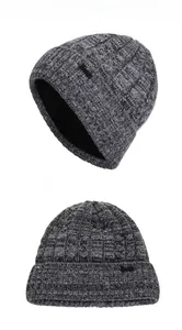 Detail view of winter cable knit hat with thick fleece lining and metallic brand emblem