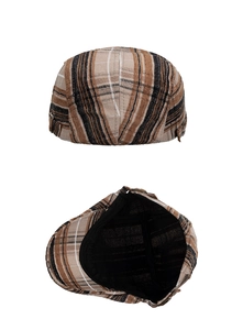 Detail view of the brown plaid beret featuring metal buckle and breathable lining