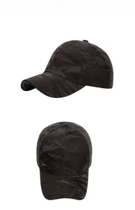 Detail view of black baseball cap showing unique pleated texture and synthetic suede material