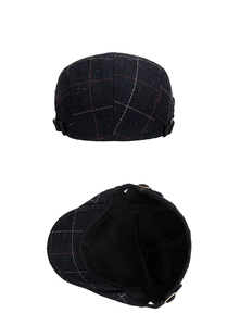 Close-up of herringbone pattern flat cap with adjustable bronze metal buckle and black lining
