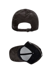 Detail view of suede baseball cap showing metal adjustment buckle and inner lining wash label