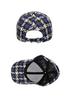 Detailed view of houndstooth baseball cap with adjustable metal buckle and inner tag