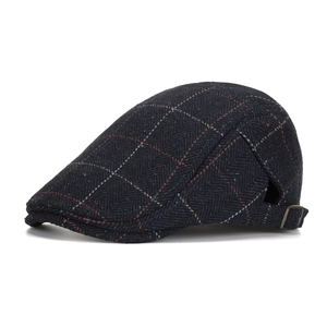Navy blue herringbone newsboy cap with orange windowpane plaid and metal side buckle