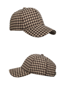 Detail view of plaid baseball cap showing vintage tweed fabric and curved brim texture