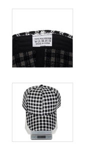 Detail of a black and white houndstooth baseball cap showing interior wash label and weight