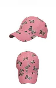 Dettaglio ravvicinato del cappellino rosa in cotone con ricamo farfalla leopardata