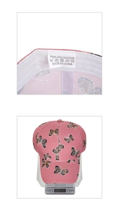 Macro dell'etichetta 100% poliestere e indicazione del peso del cappellino rosa a farfalla