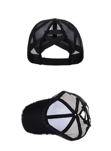 Detail view of black ponytail mesh trucker hat with cross elastic bands and floral print