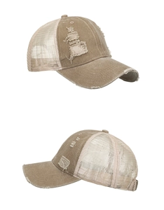 Detailed macro view showing distressed torn fabric and mesh on khaki trucker cap