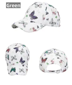 Detail view of white baseball cap with colorful butterfly prints and frayed vintage edges