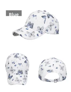 Detail view of the blue butterfly print and metal buckle on the white baseball cap