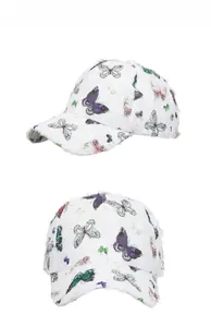 Detail view of ethnic white baseball cap featuring butterfly print and frayed distressed edges
