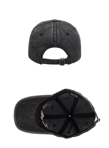 Détail de la boucle en métal et de l'étiquette en coton sur la casquette délavée