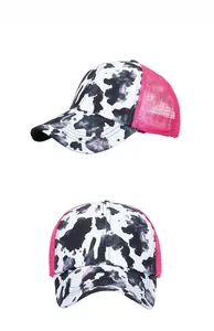 Detail view of pink mesh baseball cap with cow print pattern and ponytail hole