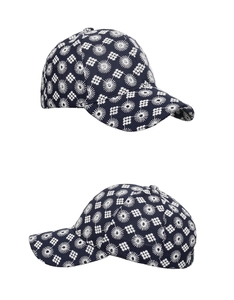 Detail of navy blue baseball cap featuring white geometric embroidery and star patterns
