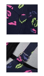 Detail of dark blue baseball cap with neon lip print and adjustable metal buckle strap