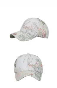 Detail view showing floral embroidery texture on a green and pink baseball cap