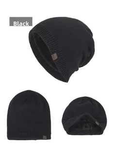 Detail of warm black knit beanie with thick fleece lining and decorative leather tag