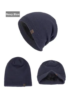 Close-up of navy blue knitted beanie with thick faux fur lining and leather logo patch