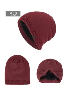 Detail view of burgundy knitted beanie with thick black faux fur lining for warmth